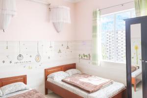 Un dormitorio con dos camas y una ventana. en Kim Tuyến Hostel - Only accept Vietnamese customers, en Da Lat