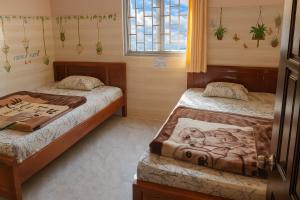 Un dormitorio con dos camas y una ventana. en Kim Tuyến Hostel - Only accept Vietnamese customers, en Da Lat 32 fotos más