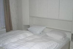 ein weißes Bett mit zwei Kissen in einem Zimmer in der Unterkunft Landgasthof Deutsches Haus in Ulmbach