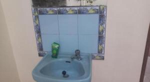 a blue sink in a bathroom with a mirror at Hotel O Endj Walet Samodra in Tepus