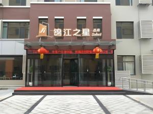 a building with a sign on the front of it at Jinjiang Inn Select Qingdao West Coast Coach Exhibition Center High-Speed Railway Station in Huangdao