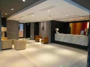 a lobby with chairs and a reception desk in a building at Jinjiang Inn Select Qingdao West Coast Coach Exhibition Center High-Speed Railway Station in Huangdao