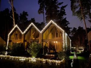 a house lit up at night with lights at Forest House Pobierowo in Pobierowo