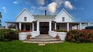 a white house with flowers in the yard at Villa Rosa in Ladismith +11 photos