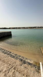 a large body of water with a pier on a beach at فيلا السعادة بيتش درة العروس رملي وخاص in Durat  Alarous
