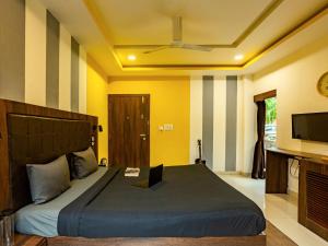 a bedroom with a large bed and a television at The Hosteller Gokarna in Gokarna