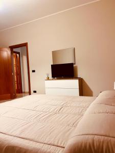 Un dormitorio con una cama blanca y un televisor. en House in Cave, en Massafra