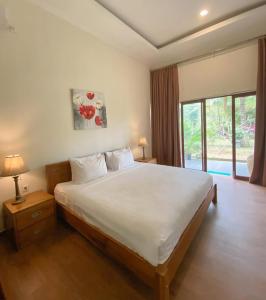 a bedroom with a large bed and a large window at Mojosurf Red Island in Pulau Lutung