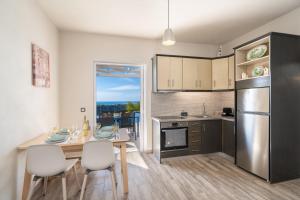 eine Küche mit Tisch und Stühlen und einem Kühlschrank in der Unterkunft Villa levanda in Mousata