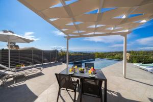 eine Außenterrasse mit Tisch und Stühlen unter einem Pavillon in der Unterkunft Villa levanda in Mousata