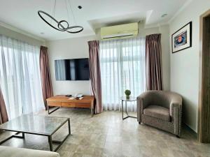 a living room with a couch and a chair and a television at La Grande Residence 1BR Corner unit Phase 2-710 in Angeles