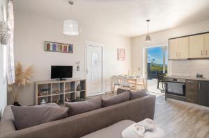 ein Wohnzimmer mit Sofa und Tisch in der Unterkunft Villa levanda in Mousata