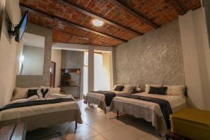 a bedroom with three beds in a room at Hotel Casa Zaragoza, San Juan de los Lagos in San Juan de los Lagos