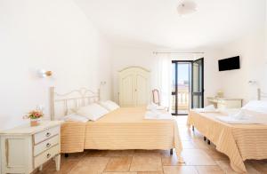 Un dormitorio con dos camas y un televisor. en Olimpo, en Giurdignano