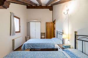 ein Schlafzimmer mit zwei Betten und einem Fenster in der Unterkunft Casa Rural El Castro in La Revilla