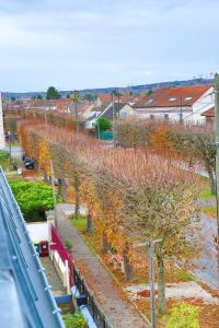 una hilera de árboles en un patio junto a una calle en Le Magelan, en Vaires-sur-Marne