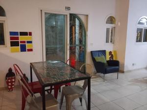 a dining room with a glass table and chairs at Charming duplex - Villa Bleue Majorelle, Saly in Saly Portudal +13 photos