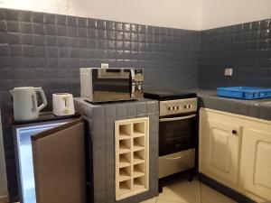 a kitchen with a stove and a microwave at Charming duplex - Villa Bleue Majorelle, Saly in Saly Portudal
