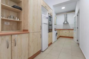 a kitchen with wooden cabinets and a white refrigerator at Apartamento centrico familiar in Santa Cruz de Tenerife