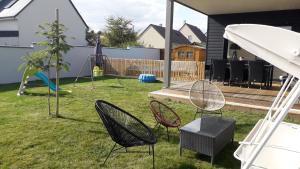 einen Garten mit Stühlen und einen Spielplatz mit Schaukel in der Unterkunft Le Virage du Circuit - Mulsanne in Mulsanne