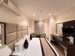 a hotel room with a bed and a desk at Alshaheen Suites in Jeddah