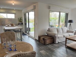 ein Wohnzimmer mit Sofa und Tisch in der Unterkunft Le Virage du Circuit - Mulsanne in Mulsanne