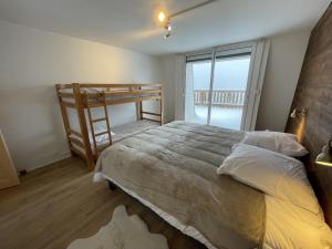 ein Schlafzimmer mit einem Bett und einem Etagenbett in der Unterkunft Chaleureux appartement Altitude 1500 in Le Lioran