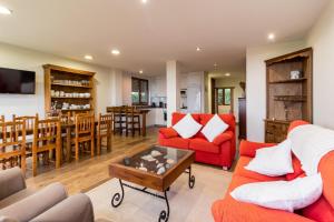 ein Wohnzimmer mit zwei roten Sofas und einem Tisch in der Unterkunft Casa Rural El Castro in La Revilla