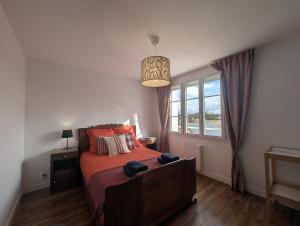 a bedroom with a bed and a window at La Maison des Vergers in Teloché