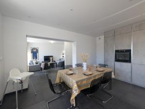 a dining room with a table and a living room at La Maison des Vergers in Teloché