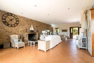 a living room with a stone wall with a clock at Kosta's House in Valaneíon