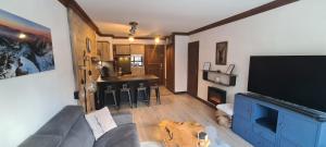 a living room with a couch and a flat screen tv at appartement de standing Arc 1950 in Bourg-Saint-Maurice