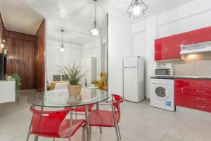 eine Küche mit einem Glastisch und roten Stühlen in der Unterkunft Estudio Céntrico Santa Cruz in Santa Cruz de Tenerife