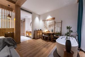 a living room with a bath tub and a kitchen at Fuxian Lake Lanshan Su Ant Nest Homestay in Xujiadu