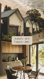 een uitzicht op een huis met een tafel en stoelen bij Sowie Chatki - domki z widokiem na Góry Sowie in Sokolec