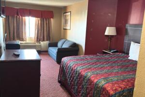 a hotel room with a bed and a couch at Broadway INN & SUITES OKC in Oklahoma City