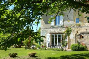 a stone house with a window and chairs in the yard at Chambre d'hôtes Domaine de Laubal in Gaillac