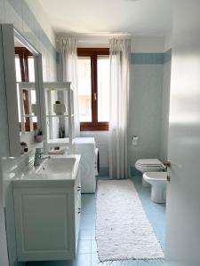 a white bathroom with a sink and a toilet at Apartment near Treviso in Silea in Silea +6 photos