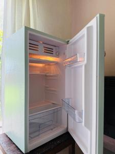 an empty refrigerator with its door open in a room at Vientos del Lago - Tu refugio en la Patagonia in Los Antiguos