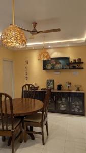 a dining room with a wooden table and chairs at Seneh Homes Cultural Stay 2BHK Dispur in Guwahati