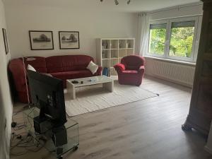 a living room with a red couch and a tv at Haus Molnar in Bad Säckingen