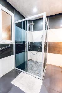 a bathroom with a shower with a glass door at villa piscine jacuzzi in Petite Île