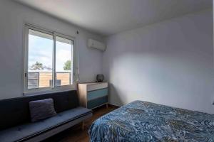 a bedroom with a bed and a couch and a window at villa piscine jacuzzi in Petite Île +16 photos