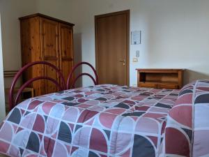 a bedroom with a bed and a wooden cabinet at Le sei palme B&B in Terralba