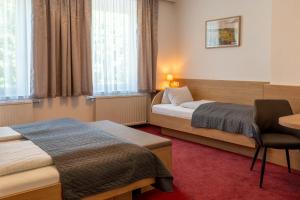 WallseeにあるGasthof Grünlingのベッド2台と机があるホテルの部屋