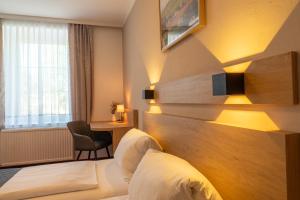 WallseeにあるGasthof Grünlingのベッドと机があるホテルの部屋 +5枚の写真