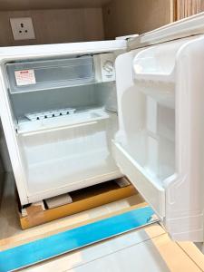 诺伊达Amigos Stays的空的冰箱,门打开