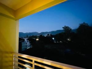 The cozy homes في دهرادون: بلكونة مطلة على المدينة بالليل