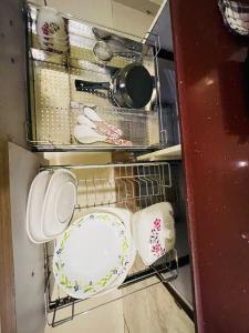 The cozy homes في دهرادون: رف وصحون وأواني في مطبخ