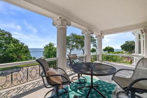 a balcony with a table and chairs and the ocean at Gorgeous Historical Mansion on the Lake Front in Racine